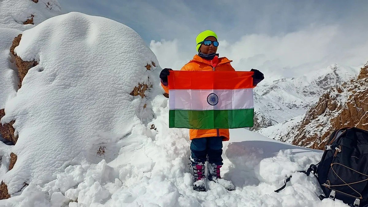 R Surya Prasad in full snow gear holding the Indian flag during his high-altitude mountaineering training