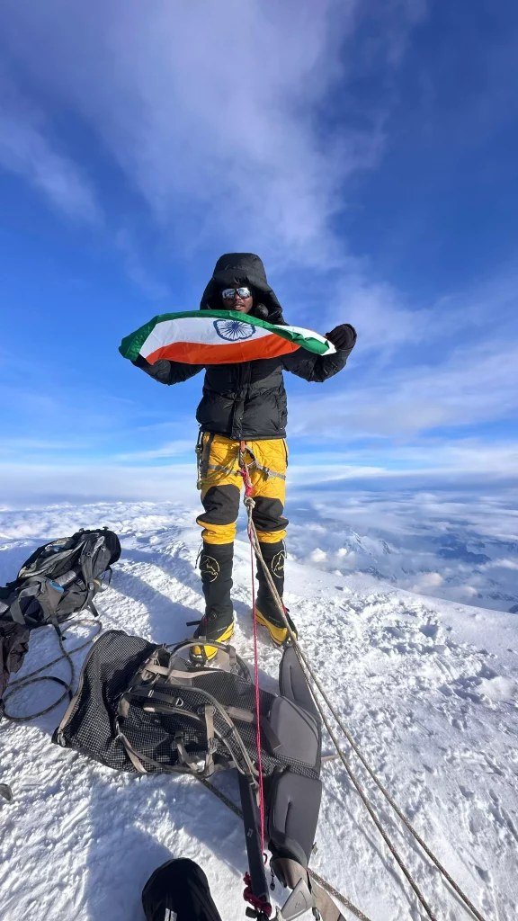 Vishwanath Karthikey Padakanti holding the Indian flag on a snowy summit